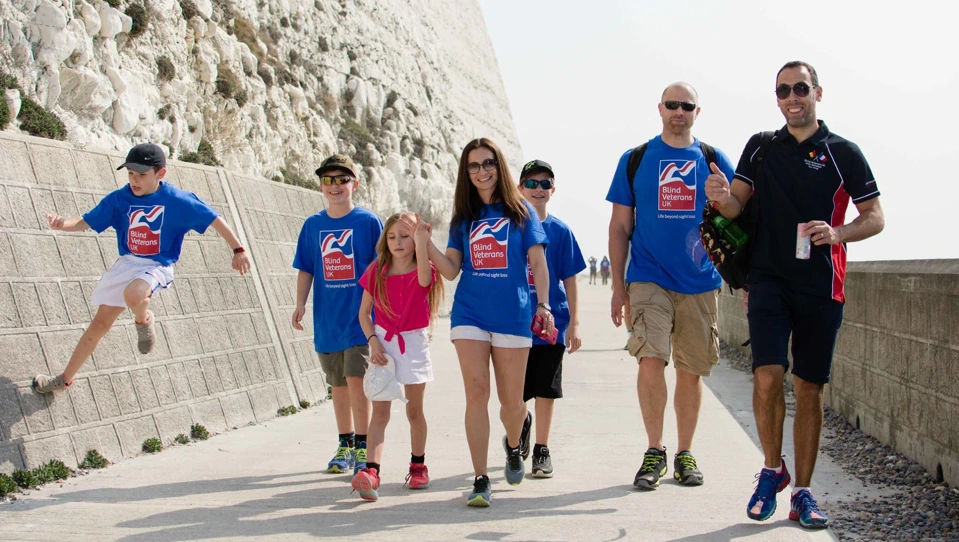 Group of supporters of all ages wearing Blind Veterans UK T-shirts while out on a walk.