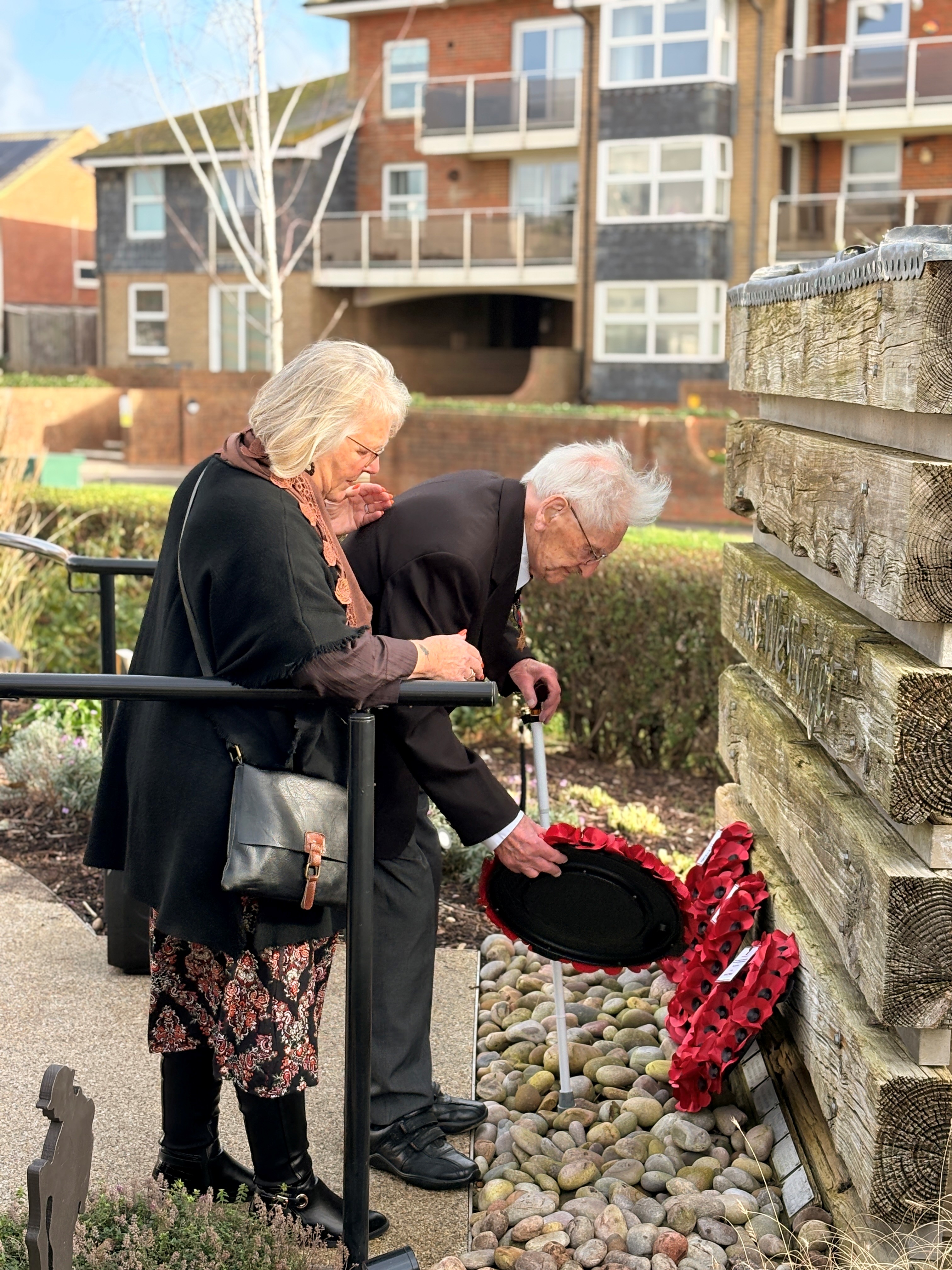 John is supported by the wife of another blind veteran to lay his wreath at the Rustington Centre