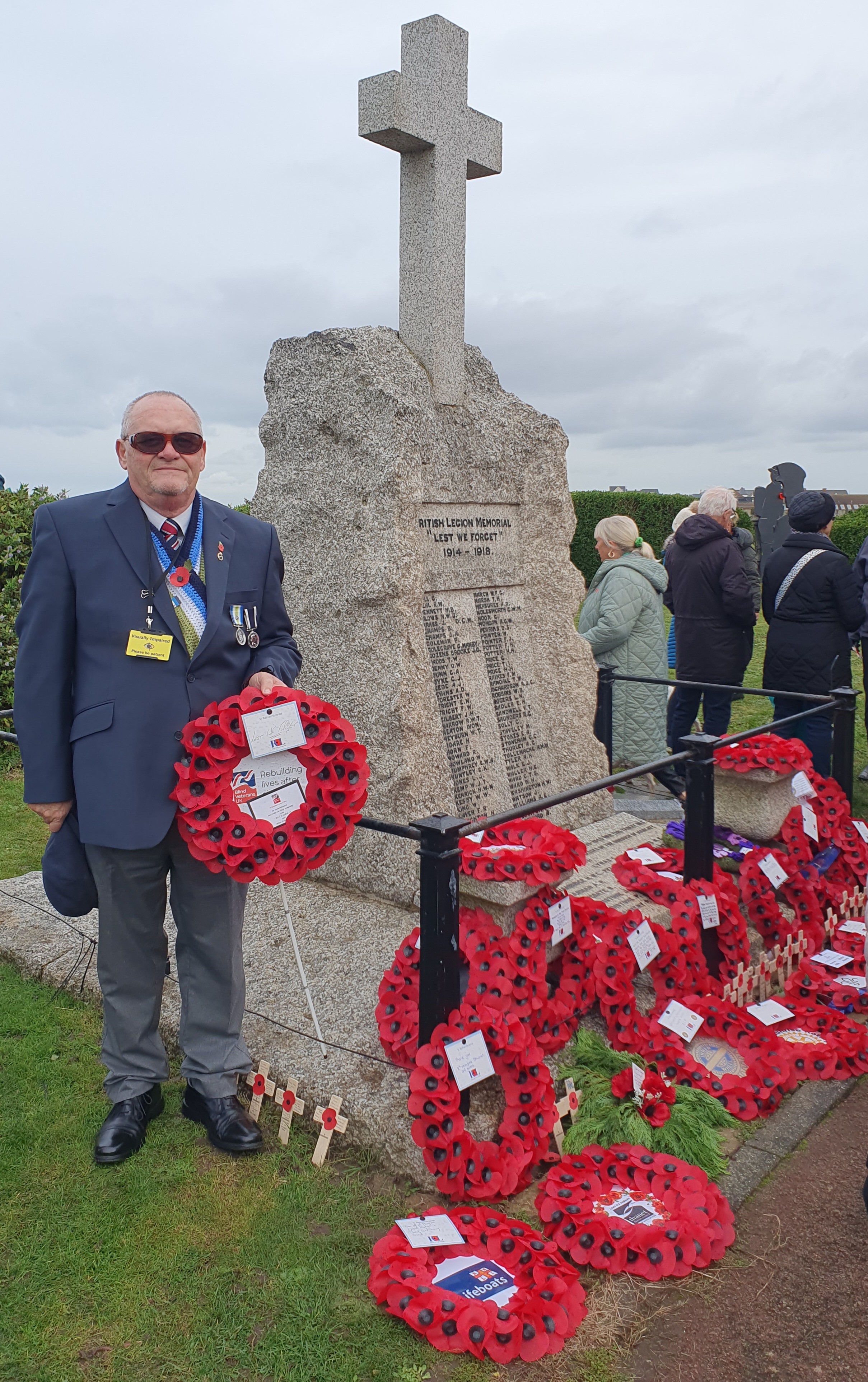 Blind veteran Ray laying a wreath at Westgate-on-Sea standing next to the war memorial