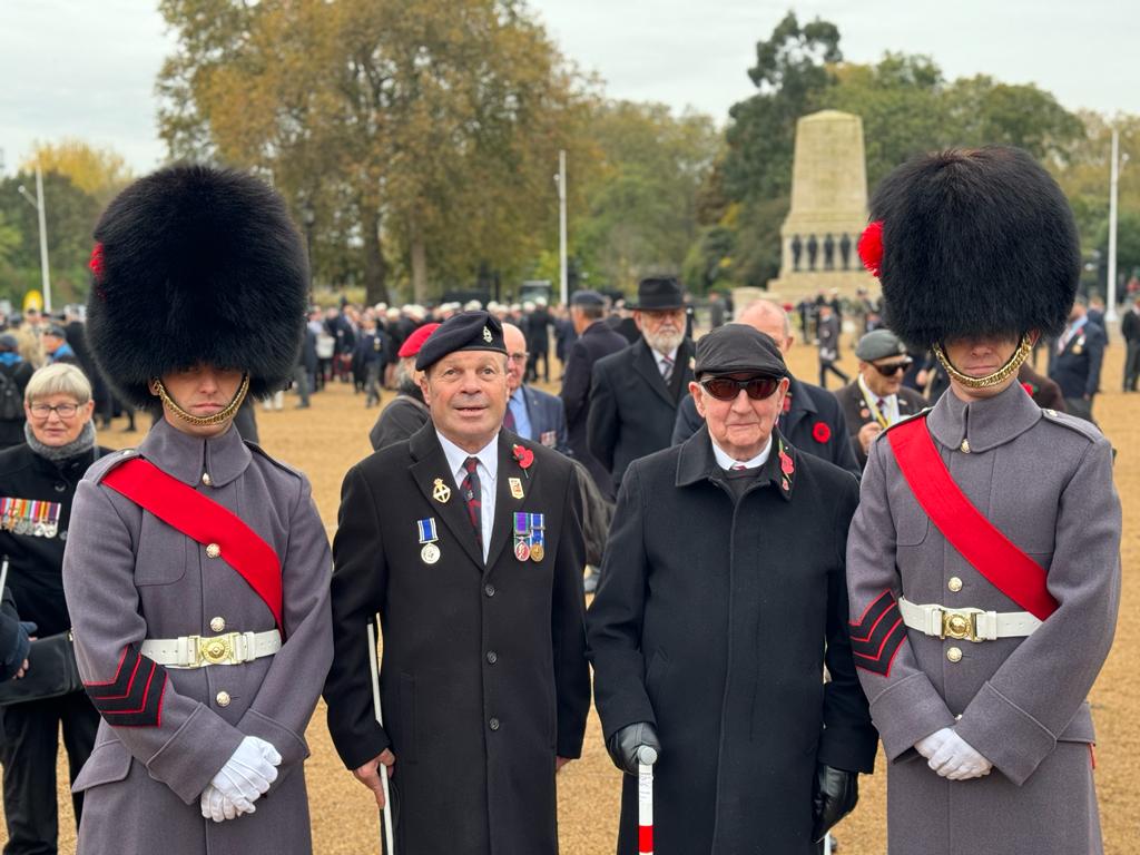 Photo of blind veteran Billy with Guardsmen waiting to start the march at the Cenotaph