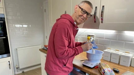 Blind veteran Mike in his kitchen using specially adapted equipment to bake