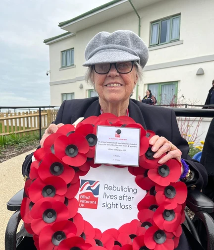 Blind veteran Nancy preparing to lay her wreath at our Rustington centre