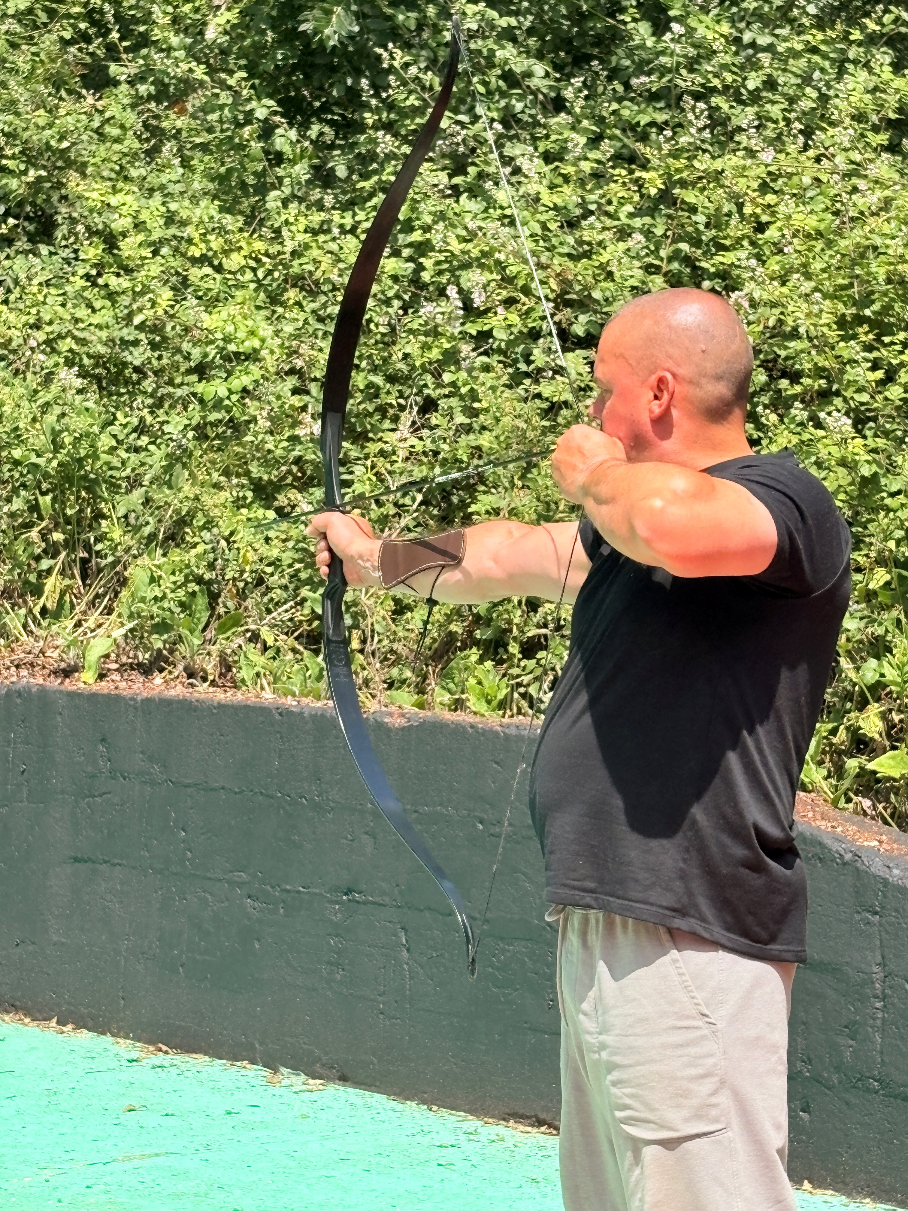 Stuart is concentrating with an arrow ready to shoot from his archery bow