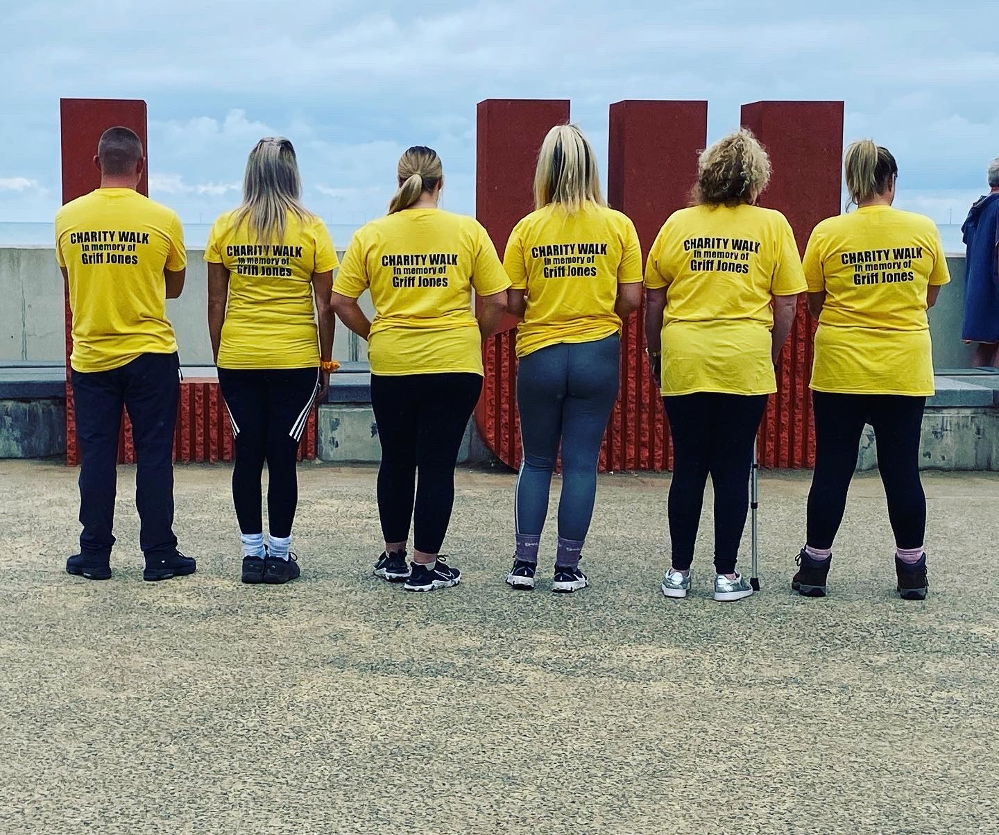 Blind veteran Griff's family, showing the back of their memorial t-shirts displaying text that says: Charity walk in memory of Griff Jones