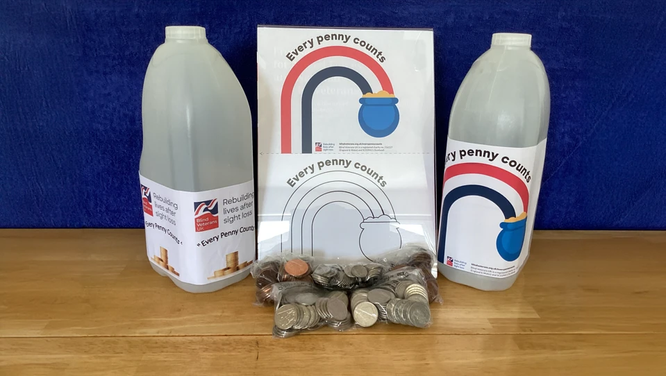 Two milk cartons with 'every penny helps' wrote on a label alongside a bag of coins and a rainbow graphic
