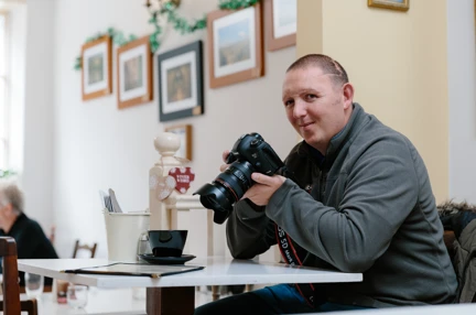A photo of Chris a blind veteran using a camera