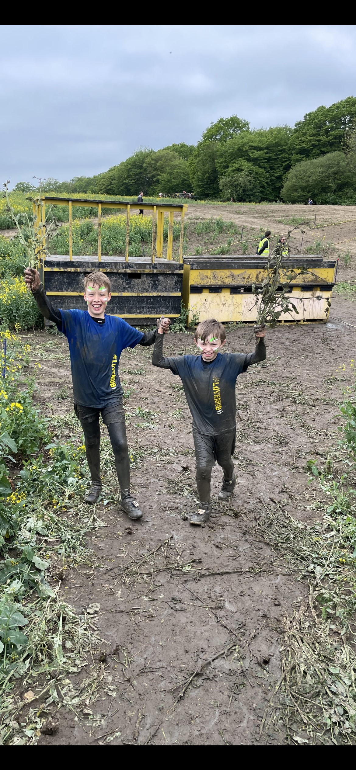 Sammy and Oakley holding hands and covered in mud from head to toe