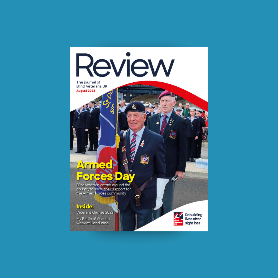 A magazine front cover with title "Armed Forces Day" and an image of a blind veteran acting as standard bearer at an event with a Blind Veterans UK flag
