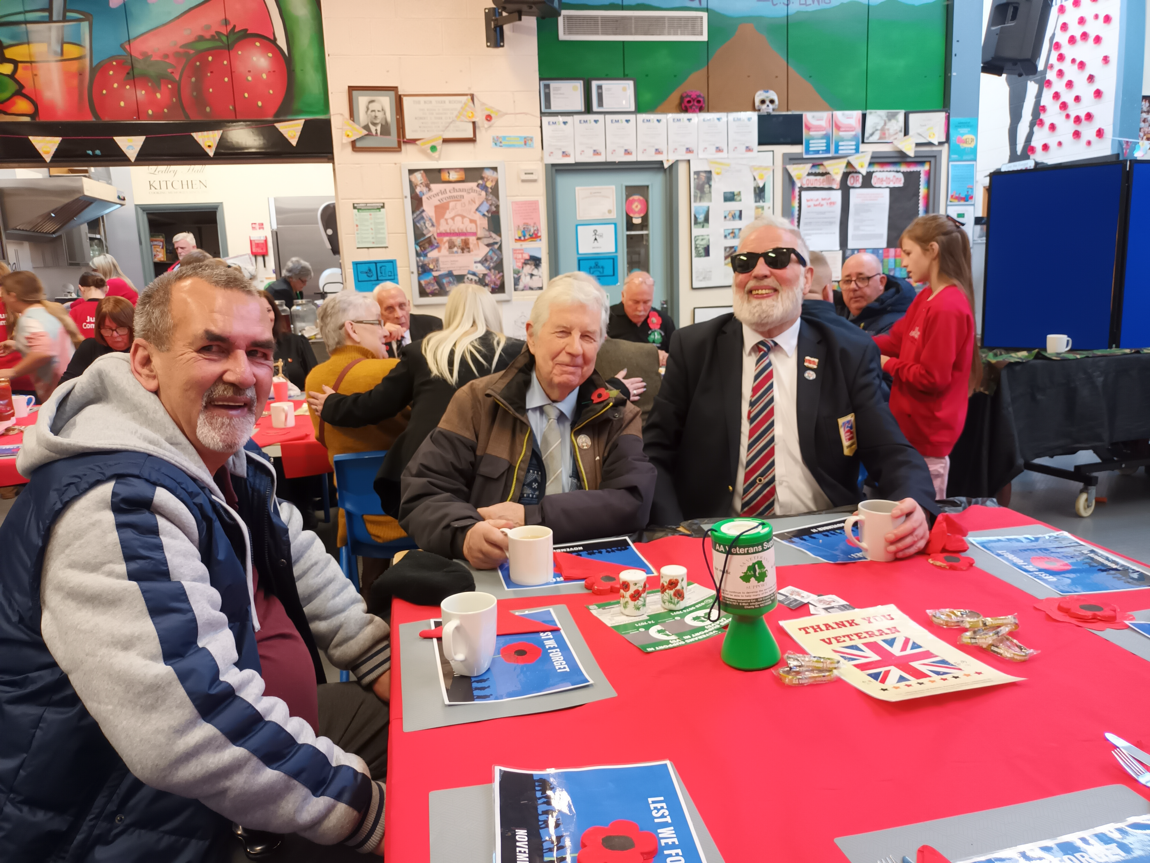 Blind veterans Alex, Gary & Hugh At Ledley Hall Remembrance Service sitting with cups of tea around a table