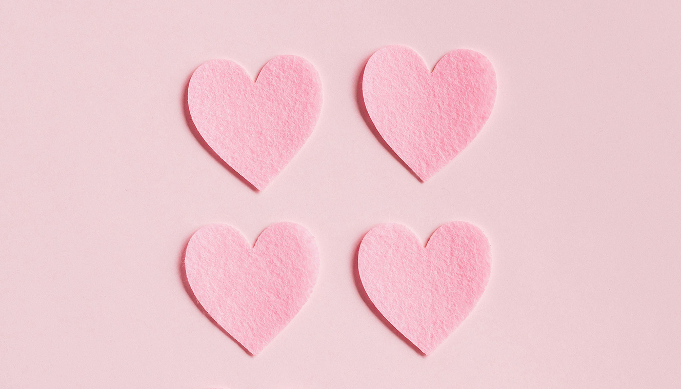 A photo of four paper love hearts