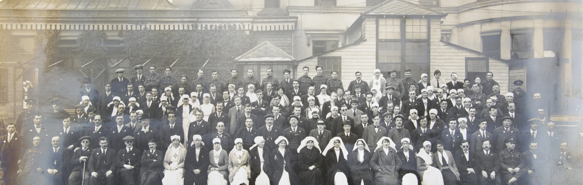 An archive group photograph of blind veterans, nurses and staff outside our headquarters at Regents Park in 1918
