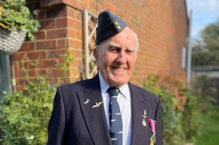 Blind veteran Michael smiling as he wears his blazer, beret and medals