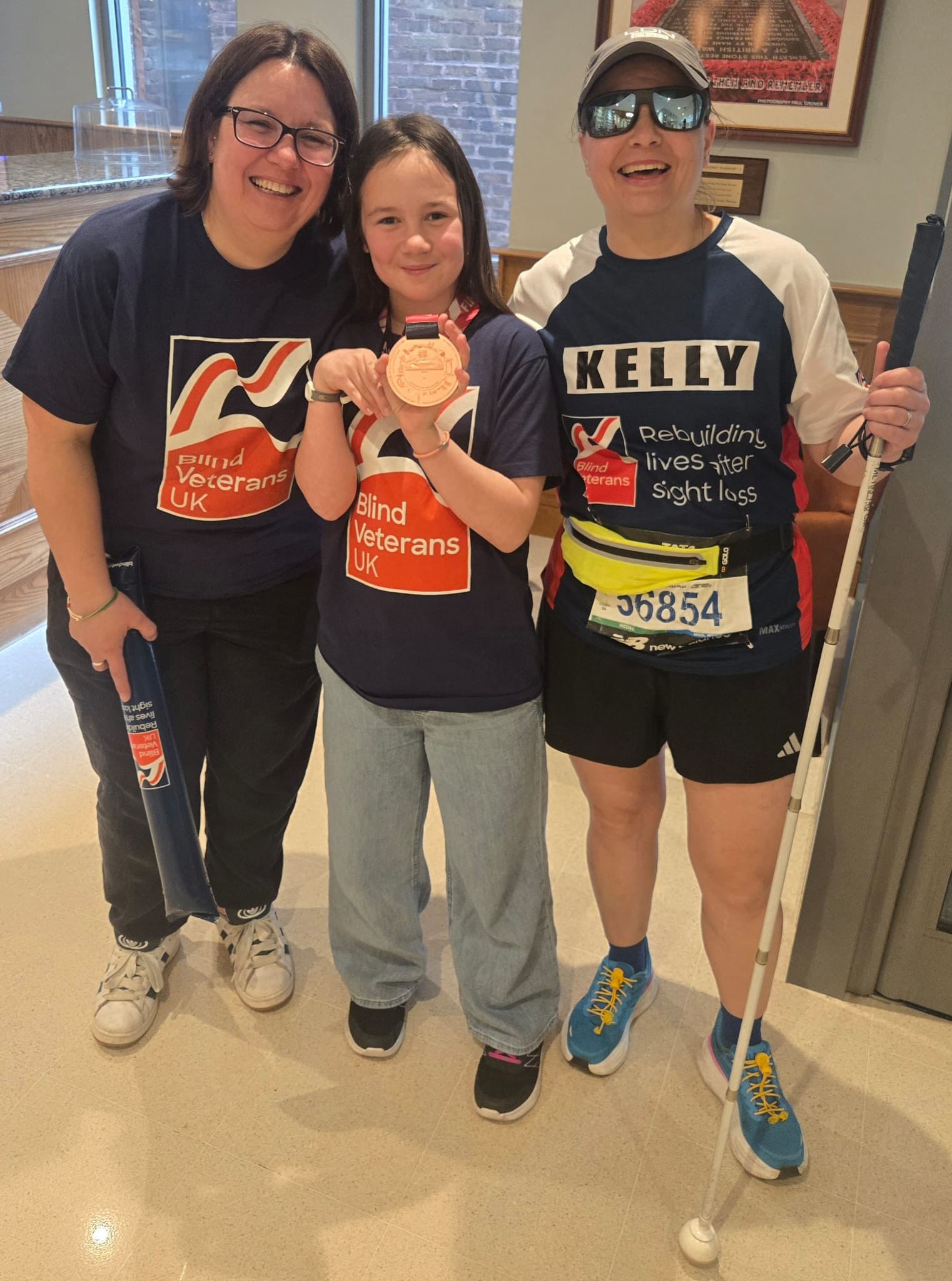 Kelly with her daughter and her wife. Kelly's daughter is holding up her medal