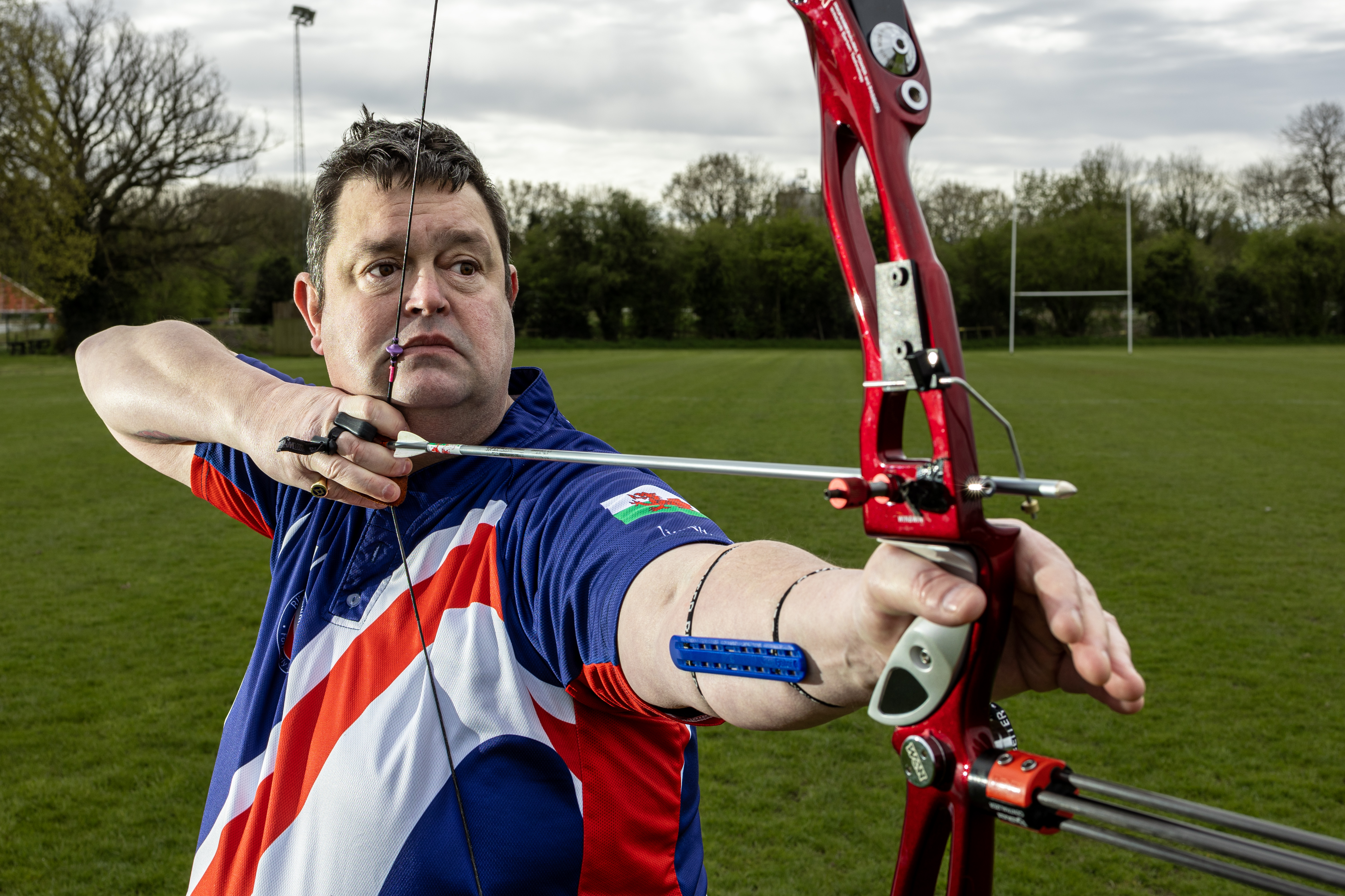 Clive wears his team BG shirt and bow as he points towards the target