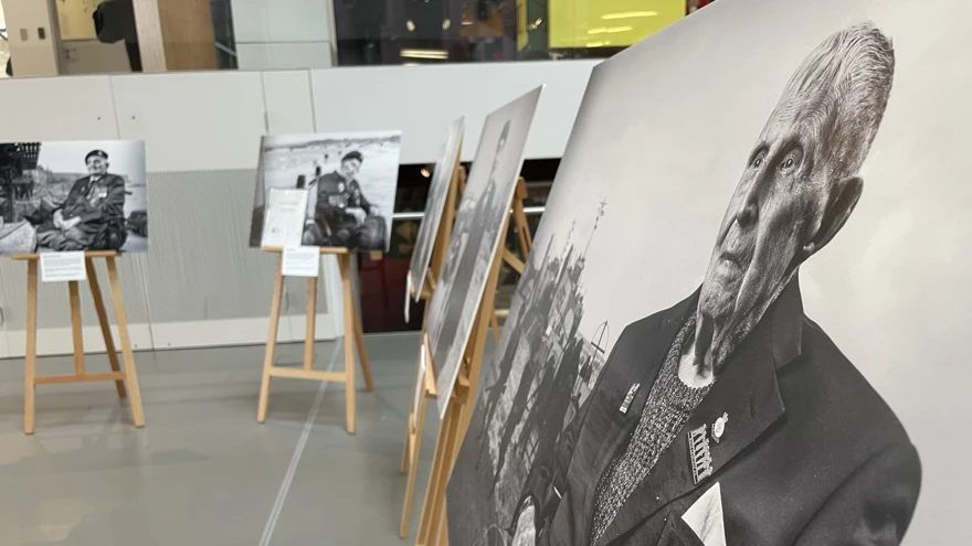 Five large black and white canvas images are displayed in a semi circle within a gallery space