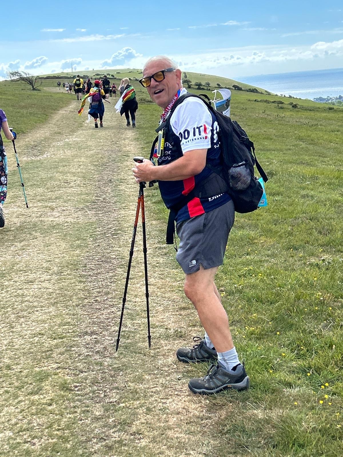 Jerry has paused for a photo during an uphill section of the coastal path. Lots of other walkers are in the background