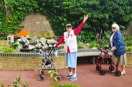 Blind veteran Nancy raises her arm in celebration of completing 100th lap
