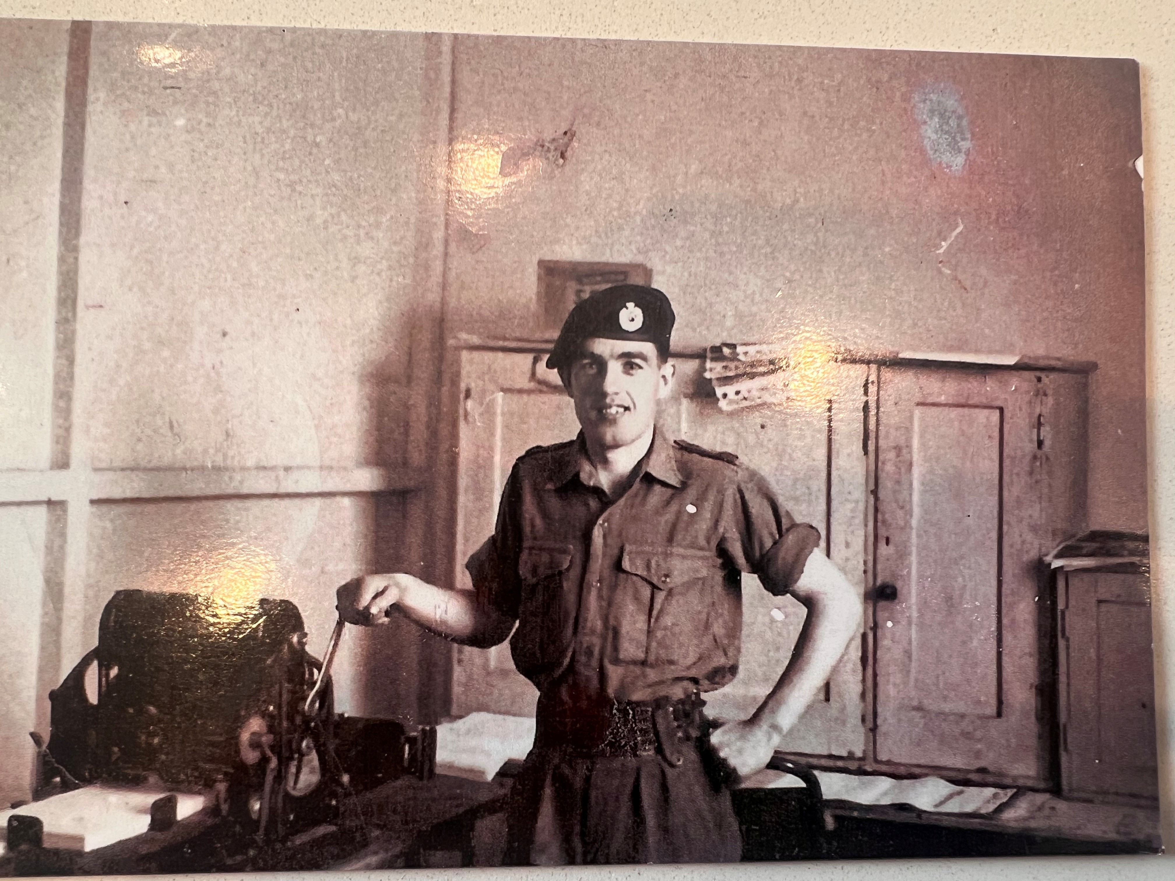 A sepia photograph of John as a young man during his military service 
