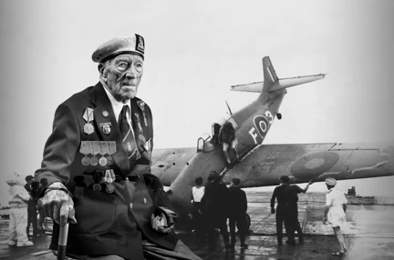 A black and white portrait of blind veteran Alec, overlaid on a scene from D-Day