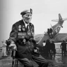 A black and white portrait of blind veteran Alec, overlaid on a scene from D-Day