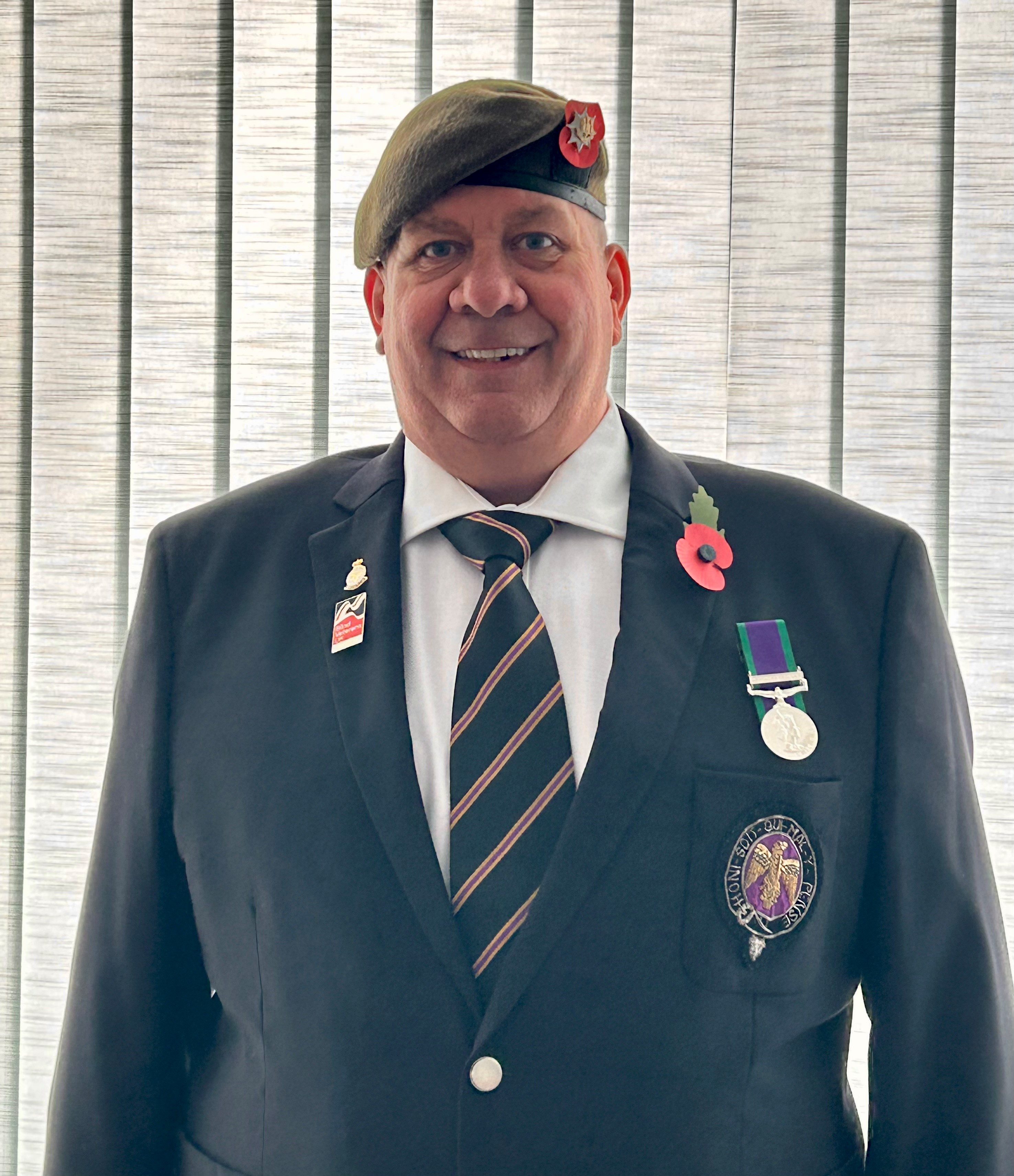 Blind veteran Mark is a navy jacket, tie, medal, and poppy