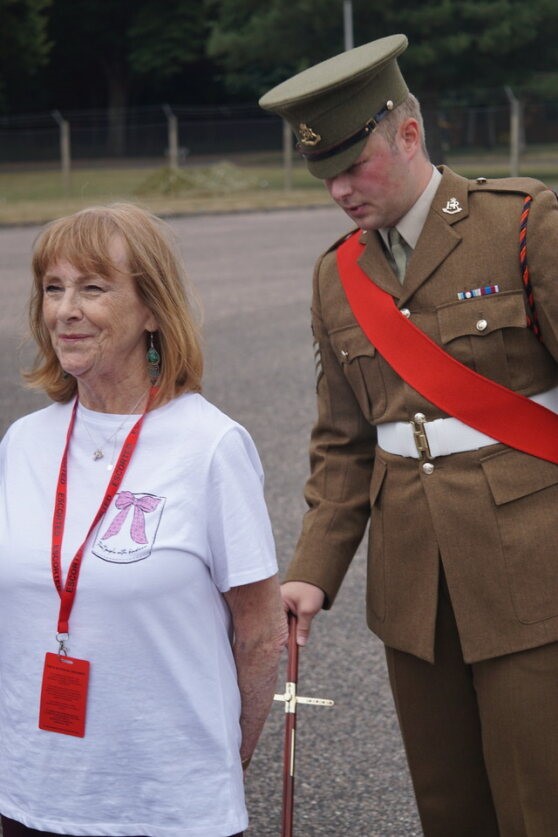 Jennie stands to attention in civilian clothes while being inspected by an Drill Sergeant