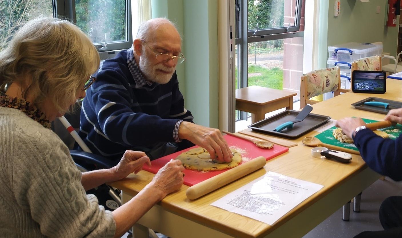 A photo of blind veteran Jack and his wife Molly rolling out dough to make Welsh cakes with the help of Alexa