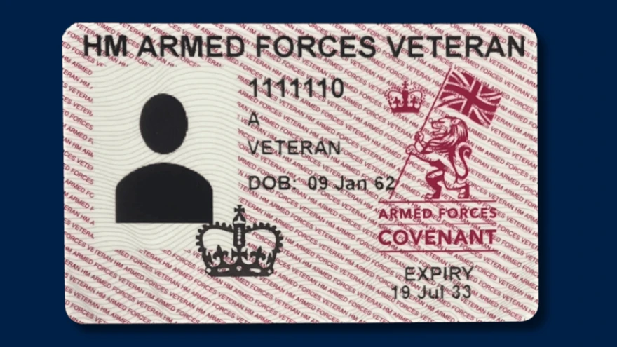 A sample UK Armed Forces Veteran ID card, with a red and white background pattern. The card features a silhouette placeholder for a photo, a sample ID number and the term "Veteran" prominently displayed. The right side of the card shows the Armed Forces Covenant logo.