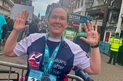 Alison with a huge smile in her Blind Veterans UK vest after finishing the Chester 10k