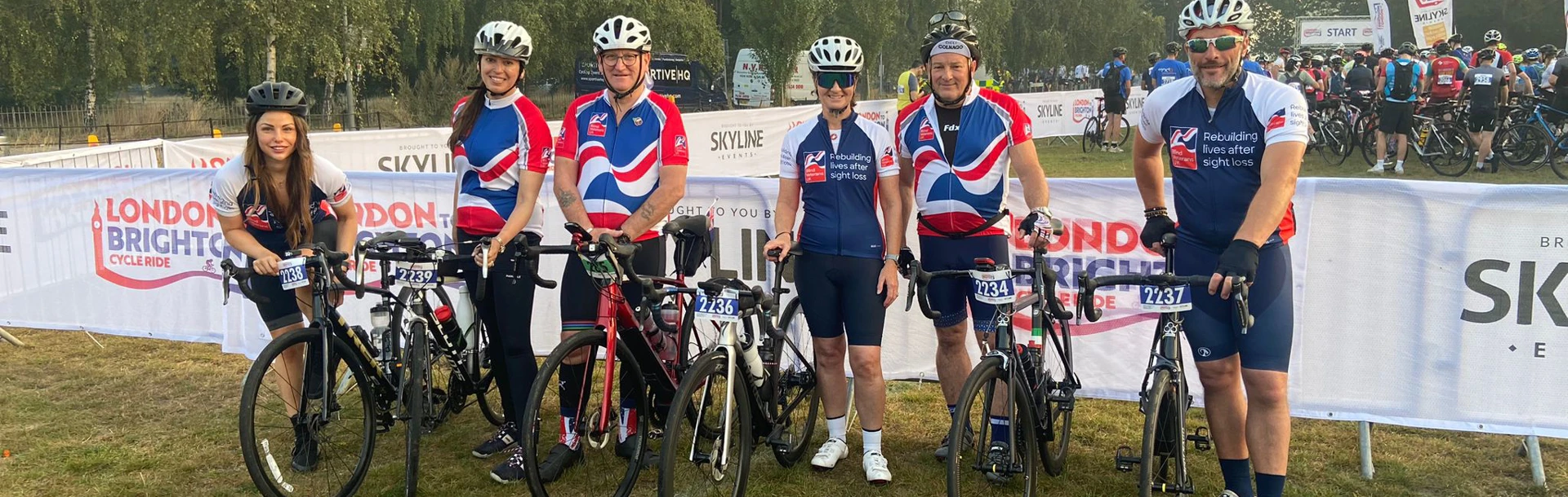 A group of six Thea employees holding up their bikes and wearing their Blind Veterans UK cycling tops