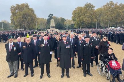 Blind veterans and guides gathered together, wearing their badges and poppys for Remembrance