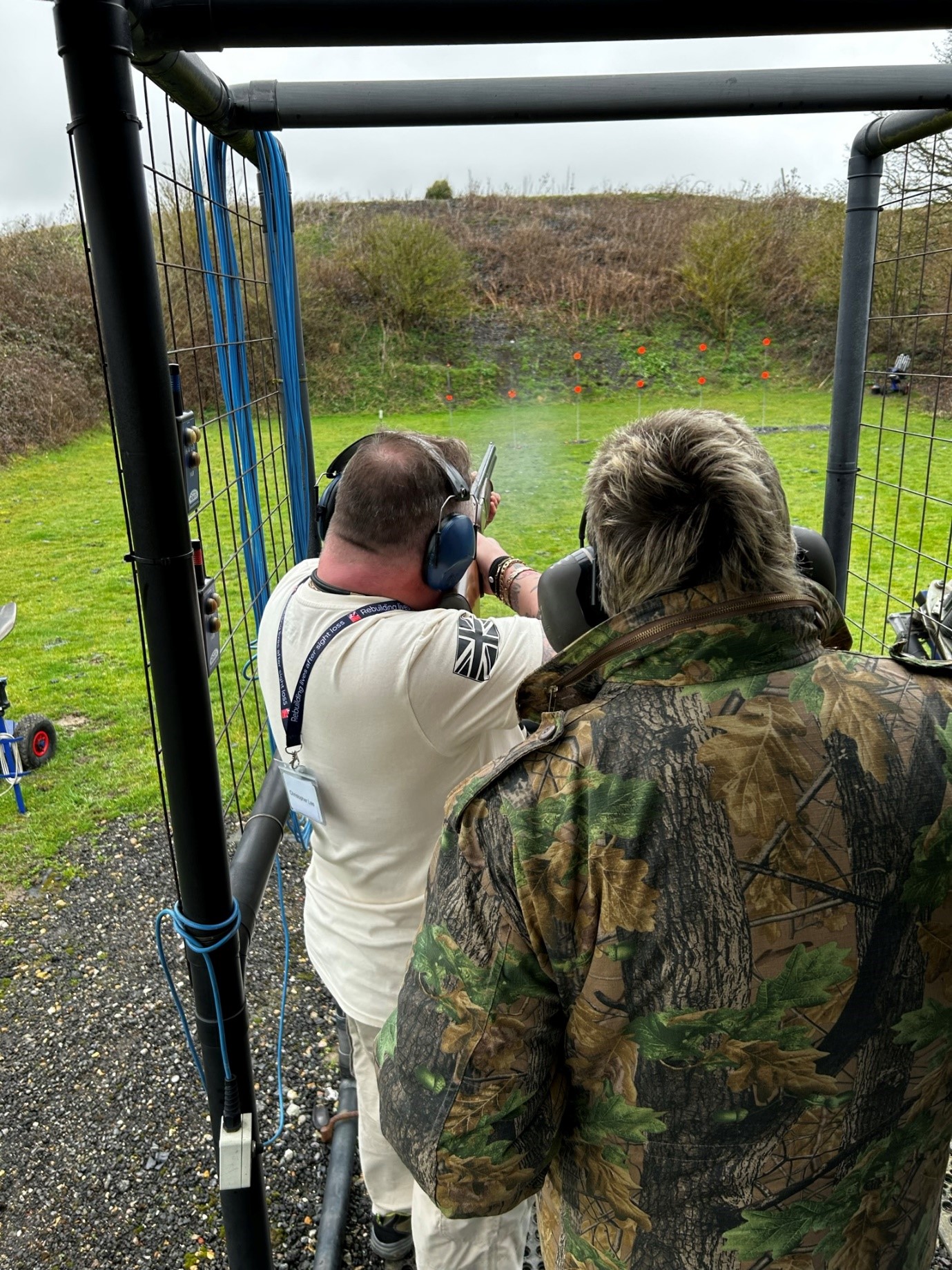 Chris with a member of staff stood behind him while he shoots at small targets